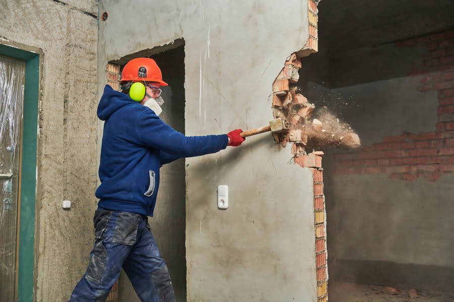 Image of a construction man or inspector destroying the house